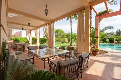 a patio with a table and chairs and a pool at Domaine Marradise in Marrakech