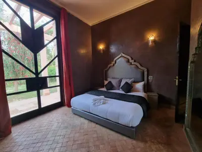 a bedroom with a bed and a large window at Domaine Marradise in Marrakech