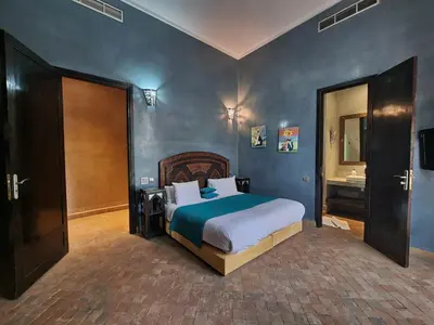 a bedroom with a large bed and a sink at Domaine Marradise in Marrakech