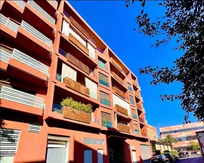 a building with potted plants on the side of it at Appartement luxueux avec vue panoramique sur l’Atlas au centre de Marrakech in Marrakech
