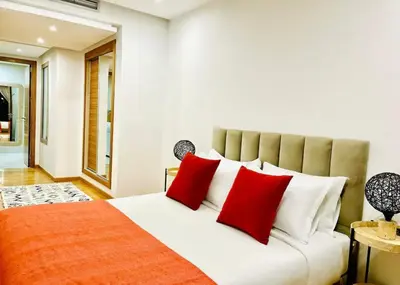 a bedroom with a large bed with red pillows at Appartement luxueux avec vue panoramique sur l’Atlas au centre de Marrakech in Marrakech