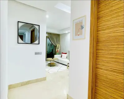 a hallway with a door leading to a living room at Appartement luxueux avec vue panoramique sur l’Atlas au centre de Marrakech in Marrakech