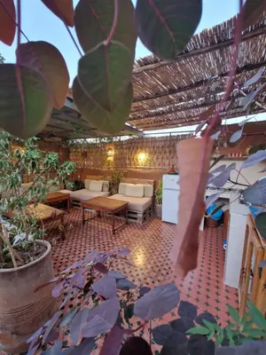 a patio with a table and chairs and plants at Medina Oasis Hostel in Marrakech