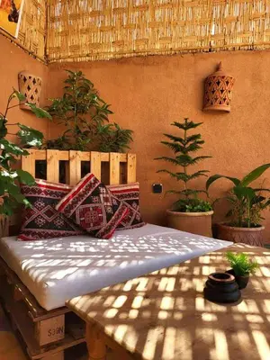 a bed with pillows on it in a room with plants at Medina Oasis Hostel in Marrakech