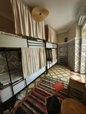 a room with four bunk beds and a rug at Medina Oasis Hostel in Marrakech