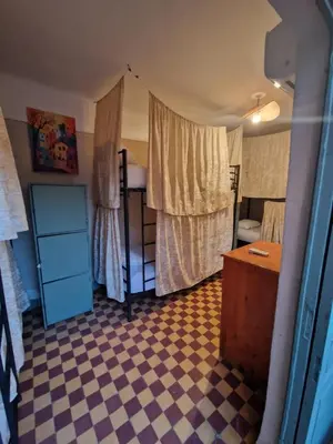a small room with a bedroom with a checkerboard floor at Medina Oasis Hostel in Marrakech