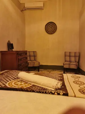 a bedroom with a bed with two chairs and a dresser at Medina Oasis Hostel in Marrakech