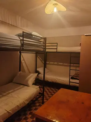 a room with two bunk beds and a table at Medina Oasis Hostel in Marrakech