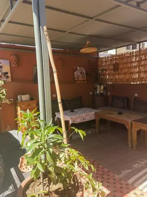 a room with a table and a couch and a table and a plant at Medina Oasis Hostel in Marrakech