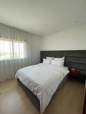 a bedroom with a large bed with white sheets and pillows at Marrakech Prestigia 3 chambres in Marrakech
