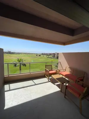 a balcony with chairs and a view of a field at Marrakech Prestigia 3 chambres in Marrakech