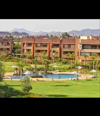 a large building with a swimming pool in a park at Marrakech Prestigia 3 chambres in Marrakech