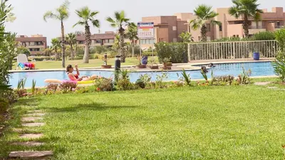 a group of people in a pool at a resort at mini-villa situee dans une residence Prestigia à Marrakech, avec une vue sur la piscine et le golf une securite 24h sur 24 et une proximite ideale de l aeroport 5 minutes C est une offre parfaite pour des vacances in Marrakech