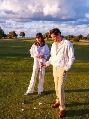 a man and a woman standing on a golf course at Appartement de Luxe avec Jardin Vue sur la Piscine Golf Securise 24h sur 24 a 5 Minutes de l Aeroport in Marrakech