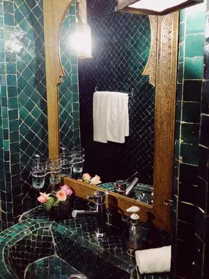 a blue tiled bathroom with a sink and a mirror at NOSADE Venue in Marrakech