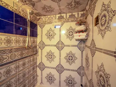 a bathroom with white and blue tiled walls at Pretty Apartment in the Medina 2 in Marrakech