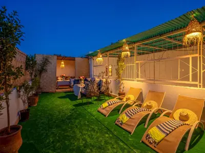 a patio with chairs and tables on the grass at Pretty Apartment in the Medina 2 in Marrakech