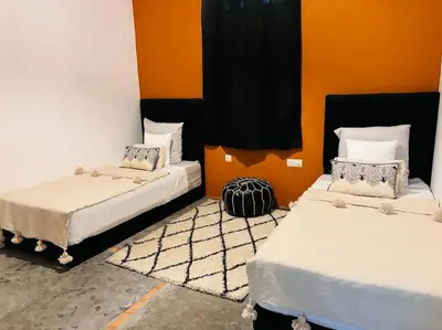 two beds in a room with orange walls at Loft Marrakech 5 min du centre super emplacement in Marrakech