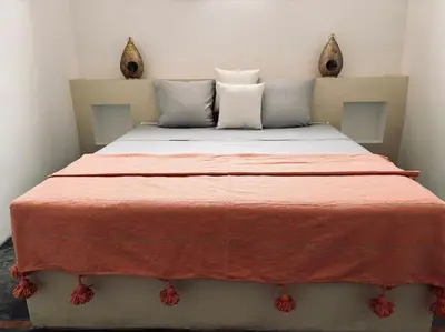 a bedroom with a bed with an orange blanket at Loft Marrakech 5 min du centre super emplacement in Marrakech