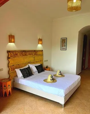 a bedroom with a large bed with hats on it at Villa Keshmere in Marrakech
