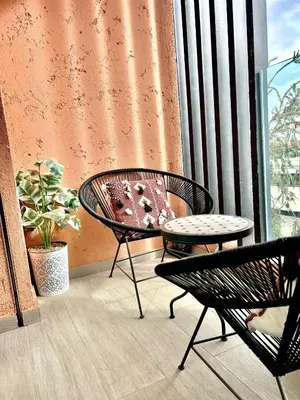 a balcony with a table and chairs and a window at Cosy appartement au Domaine de Noria in Marrakech