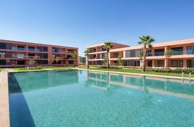 a large swimming pool in front of a building at Cosy appartement au Domaine de Noria in Marrakech