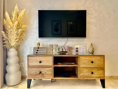 a wooden dresser with a television on top of it at Cosy appartement au Domaine de Noria in Marrakech