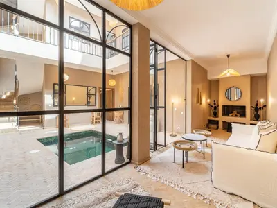 a living room with a pool and glass walls at Serenity Riad with Breakfast in Marrakech