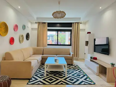 a living room with a couch and a tv at Le Gueliz Centeral cosy Suite in Marrakech