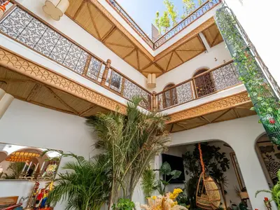 a building with a balcony with plants in it at Riad Nesayam - Riad Privatisé - 3 Suites - Piscine Chauffée in Marrakech