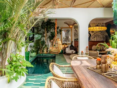 a living room with a table and chairs and plants at Riad Nesayam - Riad Privatisé - 3 Suites - Piscine Chauffée in Marrakech