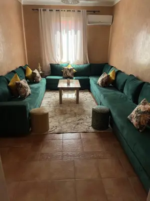a living room with a green couch and a table at Superbe appartement au porte de gueliz in Marrakech