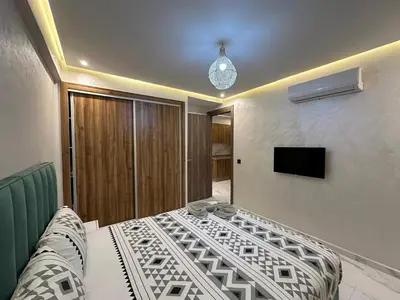 a bedroom with a bed and a television in it at Résidence Joudad Guéliz in Marrakech