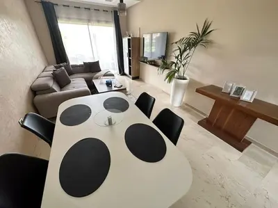a living room with a panda table and chairs at Appartement avec Piscine Prestigia Agate Marrakech in Marrakech