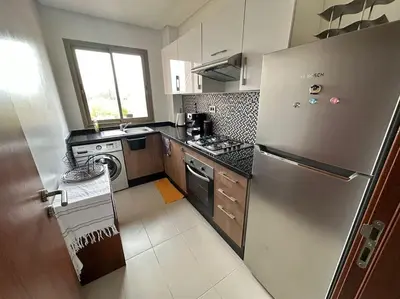 a kitchen with a stainless steel refrigerator and a stove at Appartement avec Piscine Prestigia Agate Marrakech in Marrakech