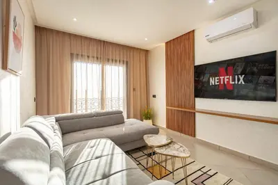 a living room with a couch and a table at RA 14 Calme et Cosy Netflix, Wifi et parking gratuits in Marrakech