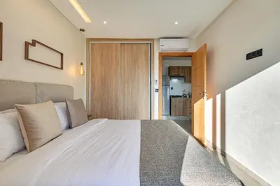 a bedroom with a bed and a door to a kitchen at RA 14 Calme et Cosy Netflix, Wifi et parking gratuits in Marrakech