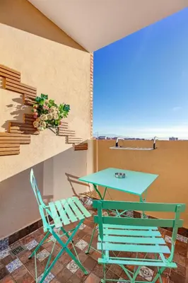 a table and chairs on a balcony with a table and chairs at RA 14 Calme et Cosy Netflix, Wifi et parking gratuits in Marrakech