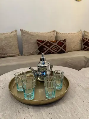 a tea kettle and four glasses on a tray on a table at Riad Le Saaliya in Marrakech