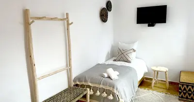 a bedroom with a bed and a tv on a wall at Couloirs de la Médina in Marrakech
