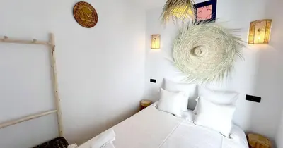 a bedroom with a bed with white sheets and pillows at Couloirs de la Médina in Marrakech
