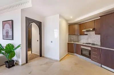 an empty kitchen with wooden cabinets and a potted plant at New, Appartement Miramas à Gueliz,en plein centre ville in Marrakech