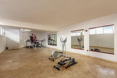 a gym with exercise equipment and people in the background at New, Appartement Miramas à Gueliz,en plein centre ville in Marrakech