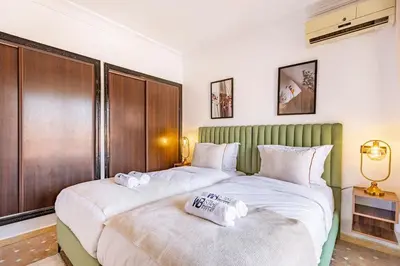 two beds in a hotel room with white sheets at New, Appartement Miramas à Gueliz,en plein centre ville in Marrakech