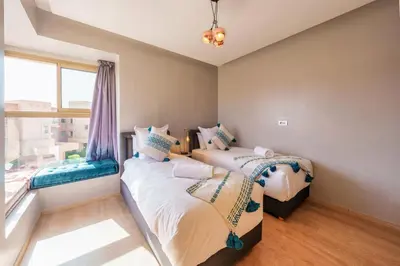 two beds in a room with a window at Relax Front Of Golf-Atlas in Marrakech
