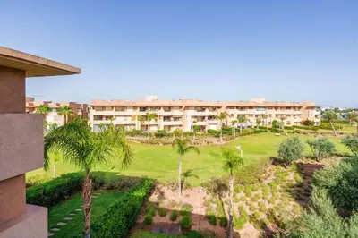 a view of a resort with palm trees and a building at Relax Front Of Golf-Atlas in Marrakech
