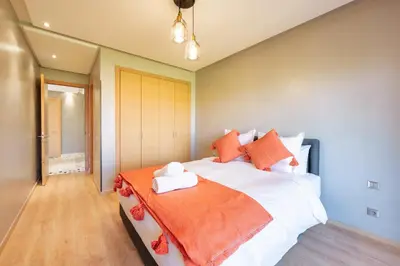 a bedroom with a large bed with orange and white pillows at Relax Front Of Golf-Atlas in Marrakech