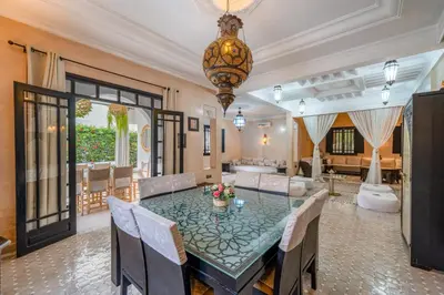 a dining room with a glass table and chairs at Villa Zeitoune - 8 pers - Piscine - Marrakech in Marrakech