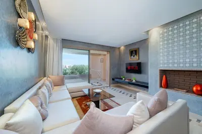 a living room with white furniture and a fireplace at Relax front of Golf-Pool-Topaze in Marrakech