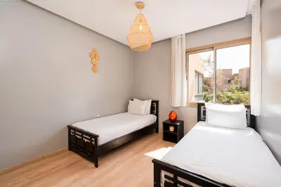a bedroom with two beds and a window at Relax front of Golf-Pool-Topaze in Marrakech